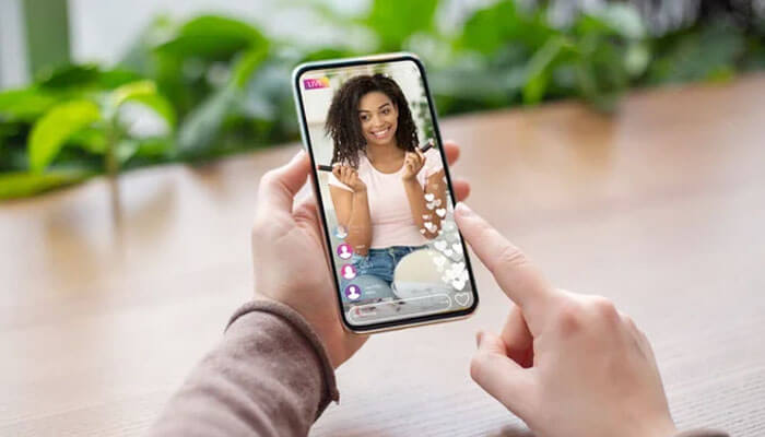 Person watching a live stream on a smartphone, illustrating social media interaction and representing pfp meaning in text visually.