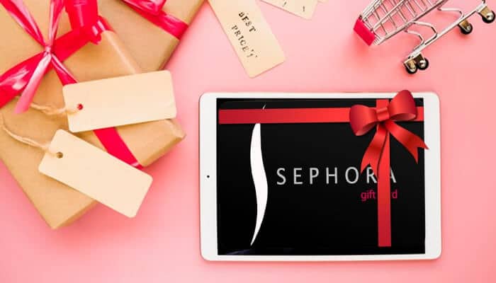 Hand holding Sephora gift card in front of Sephora store – complete guide on where to buy Sephora gift cards online and in stores.