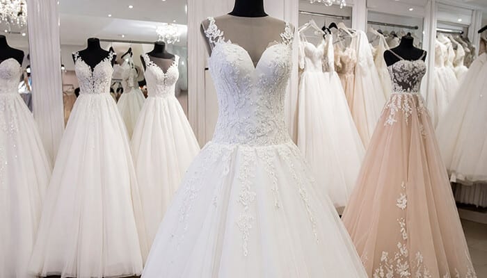 Collection of A Line Wedding Dresses featuring lace bodices and tulle skirts in a modern bridal boutique.