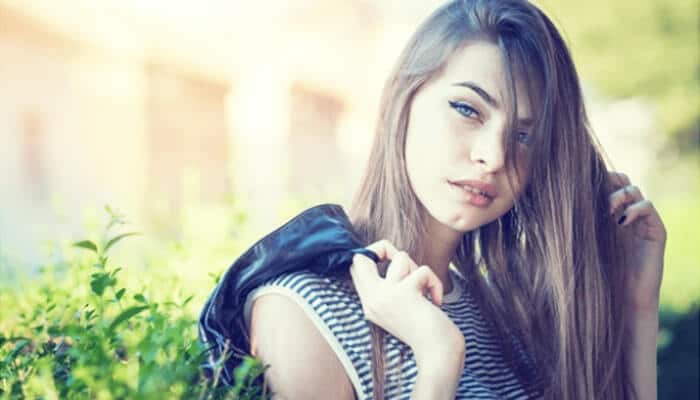 Chin dimples - Fashion in beauty - Fashion in Beauty Young woman with long hair and a serious expression, demonstrating a subtle chin dimple in the Types of Dimples section.