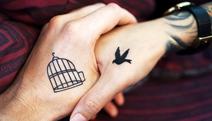 Couple Tattoo Ideas With Meaning - Fashion in beauty - Fashion in Beauty Unique couple tattoo ideas with a bird and cage design, representing freedom and love.