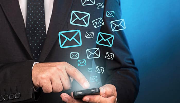 Businessman using a smartphone with floating email icons, promoting Shein coupon code for exclusive discounts and offers.