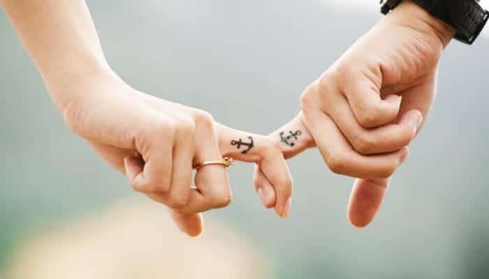Matching Tattoos for Couples - Fashion in beauty - Fashion in Beauty Couple tattoo ideas with matching anchor tattoos on fingers, symbolizing stability and commitment.