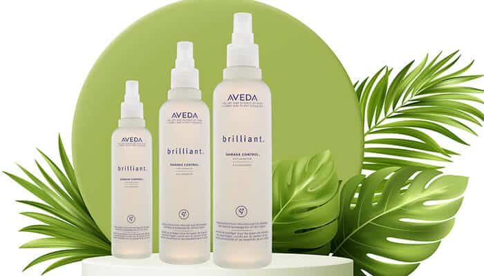 Aveda Brilliant Damage Control - Fashion in beauty - Fashion in Beauty Aveda Brilliant hair sprays displayed with botanical leaves, showcasing a lightweight formula ideal for shine and protection, featured as a Best Heat Protectant Spray for daily styling.