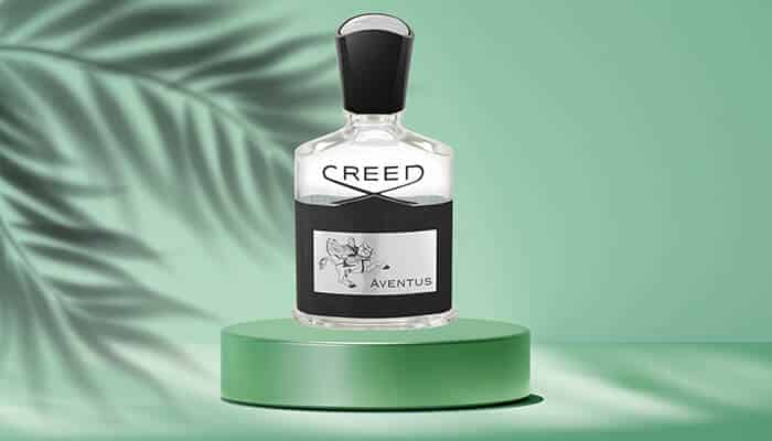 Creed Aventus - Fashion in beauty - Fashion in Beauty Best Fragrances highlighting Creed Aventus perfume bottle on green pedestal with soft shadow background.