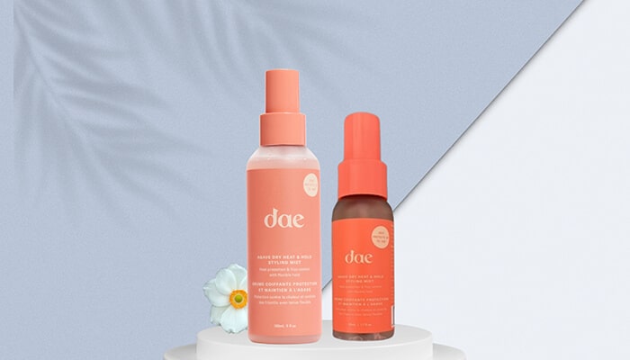 Dae Agave Dry Heat Protection Hold Styling Mist - Fashion in beauty - Fashion in Beauty dae heat styling sprays displayed on a soft pastel podium, featuring lightweight thermal protection and frizz control as a Best Heat Protectant Spray for everyday styling.
