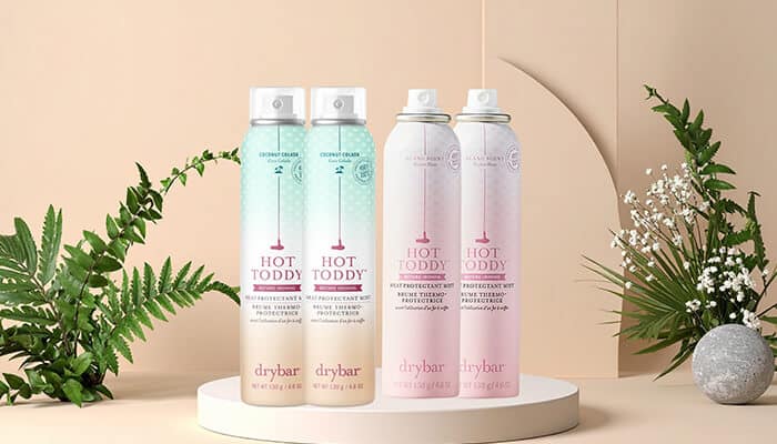Drybar Hot Toddy Heat Protectant Mist - Fashion in beauty - Fashion in Beauty Drybar Hot Toddy heat protectant sprays displayed with natural decor, offering lightweight thermal defense and shine as a Best Heat Protectant Spray for blow-dry styling.