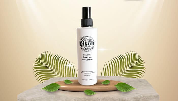 Gisou Propolis Infused Heat Protecting Spray - Fashion in beauty - Fashion in Beauty Gisou heat protectant spray presented with natural leaves, designed to nourish hair while shielding it from heat damage as a Best Heat Protectant Spray.
