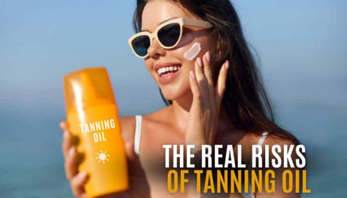 The Real Risks of Tanning Oil - Fashion In Beauty - Fashion in Beauty What Does Tanning Oil Do A sunlit beach scene showing a woman wearing sunglasses applying tanning oil labeled “Tanning Oil,” alongside on-image text highlighting “The Real Risks of Tanning Oil,” visually demonstrating how tanning oil increases UV exposure, accelerates melanin response, and raises concerns about sunburn, premature aging, and skin damage when used without proper SPF protection.