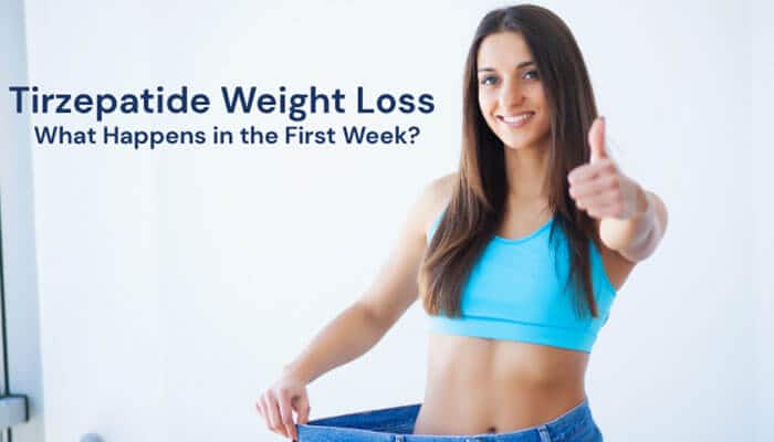 Tirzepatide Weight Loss What Happens in the First Week - Fashion In Beauty - Fashion in Beauty Smiling fit woman in blue sports bra holding oversized pants and giving thumbs up, demonstrating Tirzepatide Weight Loss progress during the first week of treatment and early fat loss results.