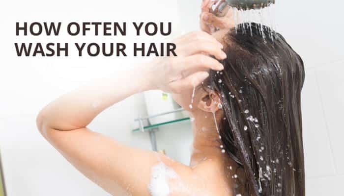 How Often You Wash Your Hair - Fashion In Beauty - Fashion in Beauty A realistic bathroom scene showing a woman washing her hair under a running shower, illustrating how frequent hair washing can affect color retention and fade speed, directly related to the focus keyword “How Long Does Darhergao Last in Hair,” highlighting how shampoo frequency influences the longevity of herbal semi-permanent hair dye like Darhergao.
