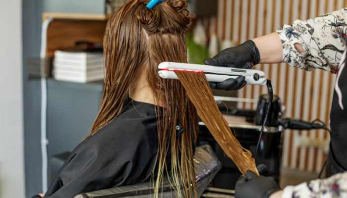 Divide Hair Into Sections - Fashion In Beauty - Fashion in Beauty TYMO Hair Straightener used for sectioning and styling hair, showing a professional hair straightening process with controlled heat application for smooth, frizz-free, salon-quality results and precise hair management.