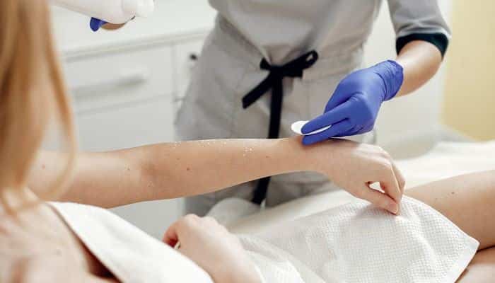 Dermatological Procedures for IGH - Fashion In Beauty - Fashion in Beauty Dermatology professional examining a patient's arm during a skin treatment, illustrating care options for White Spots on Skin From Sun.